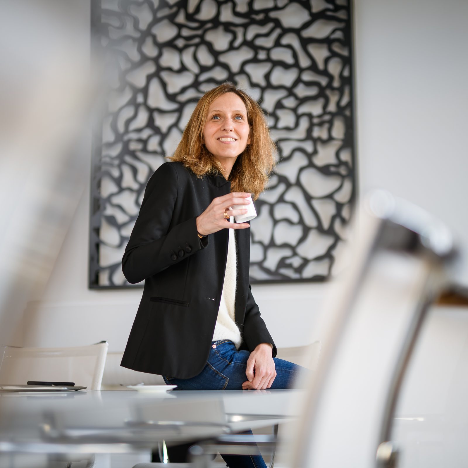 Morgane Soulier assise sur le bord d'une table, une tasse à la main
