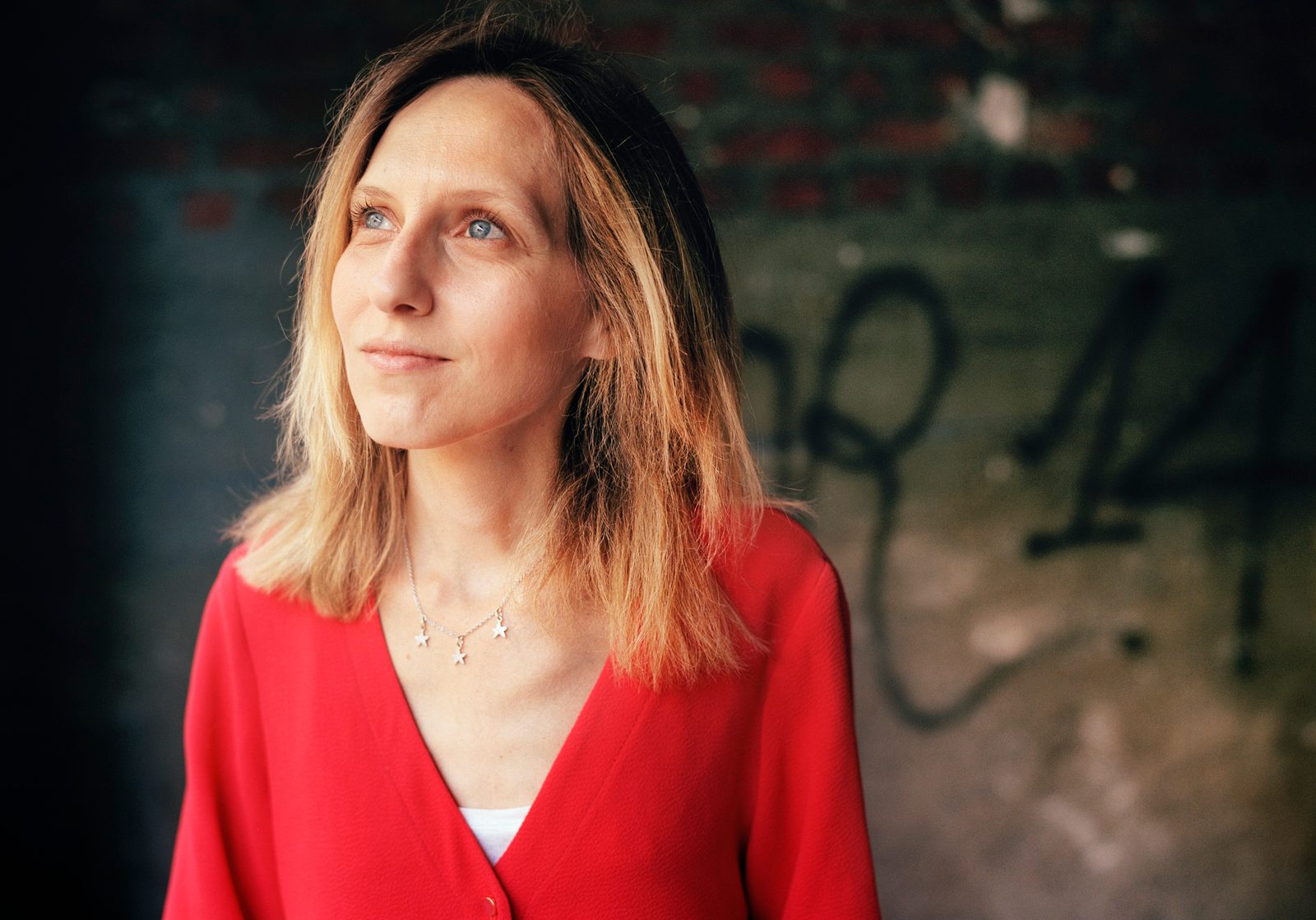 Portrait de Morgane Soulier en haut rouge, le regard tourné vers la lumière
